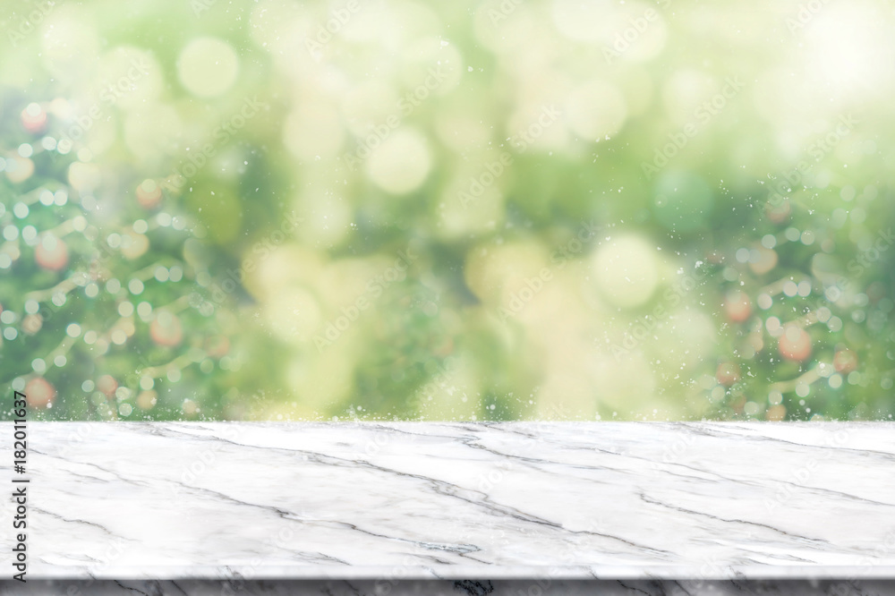 Fototapete empty white marble table top with abstract green blur christmas tree and snow fall background with b