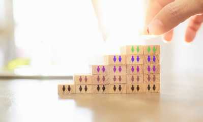 Hand of manager putting wood block on top pyramid .Human resource and recruitment business concept.