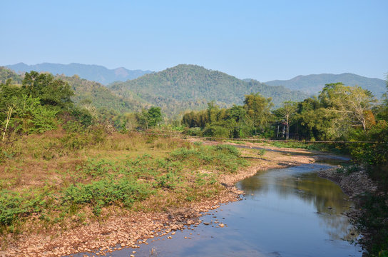 Landscape of forest and mountain with stream in morning time at Ban Bo Kluea village of Nan, Thailand