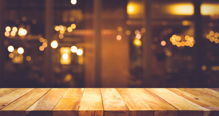 Wood table top (Bar) with blur light bokeh in dark night cafe,restaurant background .Lifestyle and...