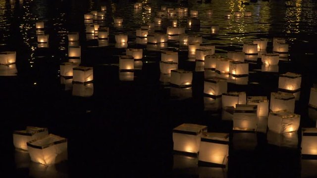 The light of paper lanterns floating on the water of Vltava illuminating the dark of Prague