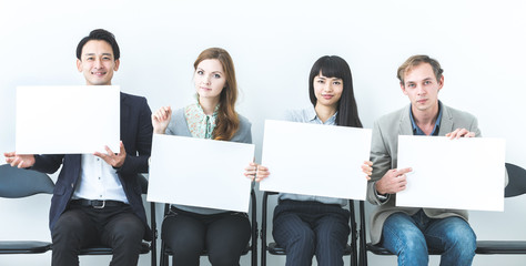 Group of people showing white boards.