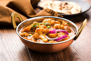 Aloo Gobi matar is a famous Indian curry dish with potatoes and cauliflower and green peas, selective focus   © StockImageFactory