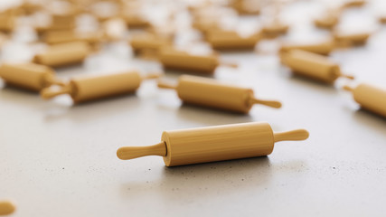 wooden rolling pins scattered on a white surface with shallow depth of field