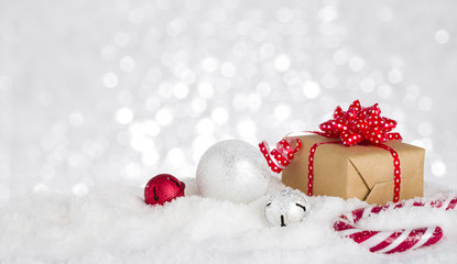 Christmas gift box and decoration in snow against bokeh background