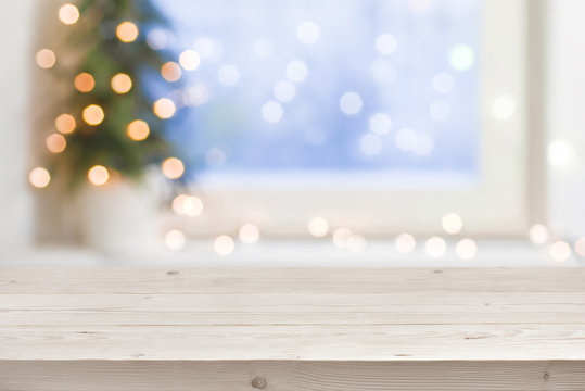 Empty wooden table in front of blurred winter holiday background