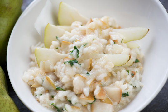 Close-up of a white plate with pear risotto, selective focus, horizontal shot