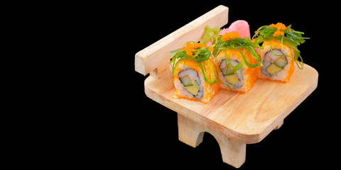 Japanese Cuisine -  Sushi Roll on wood plate on black background and space for text