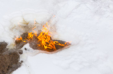 Flame of fire on white snow in winter