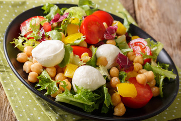 Hearty vegetable salad with chickpeas and mozzarella cheese close-up. horizontal