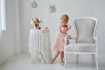 Cute little girl in a pink dress. Portrait on a white background in a romantic vintage style