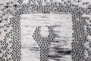 Nut wrench from metal nuts background. Flat lay.