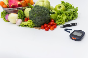 Glucose meter with  fresh  raw vegetables and fruits , desk of healthy organic vegetables, concept for healthy eating and diabetes.