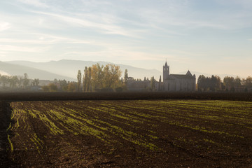 Country near Assisi (Umbria) at dawn, with cultivated field and Rivotorto church at the distance