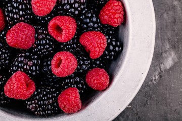 fresh ripe organic raspberries and blackberries in a bowl closeup