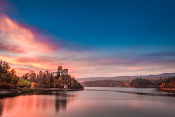 Wonderful castle by the lake in autumn at sunset