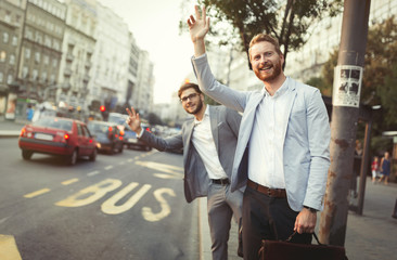 Business men hailing a cab in busy city