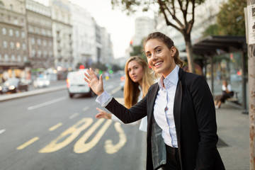 Business women waving for taxi