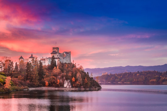 Beautiful castle by the lake in autumn at dusk
