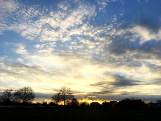 Fototapeta premium sunrise in a autumn view of German village in sun rays near Alps
