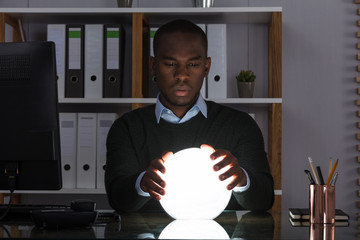 Businessman Predicting Future With Crystal Ball