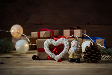Concept Christmas and New Year, gifts, fir cones, toys and heart on a wooden background