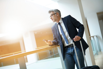 Businessman with suitcase at airport departure hall