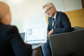 Business partners meeting in office lobby