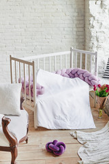 Fototapeta na wymiar Baby room: bed on white brick background