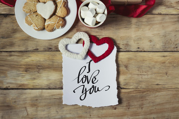 Cookies in the form of hearts, marshmallow and two handmade hearts. Inscription I love you