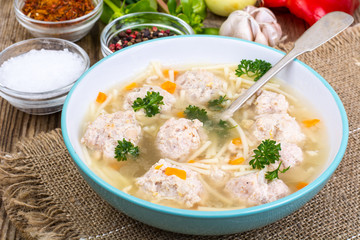 Soup with meatballs for dinner on wooden background
