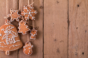 Christmas gingerbread hanging over wooden background.