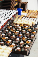 Wooden and black dishes with different kinds of desserts served on a black table