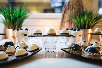 Delicious desserts made in white and black colors served on a candy bar
