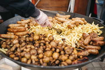 Large frying pans with vegetables stand on gas outside