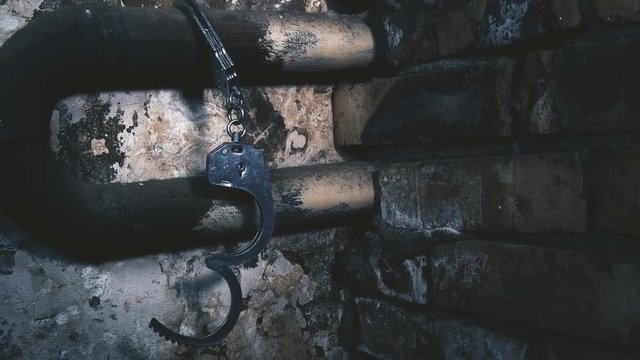 the handcuffs chained to a pipe in an old building