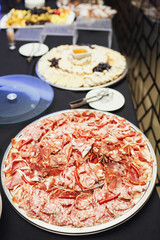 Large steel dish with sliced meat