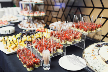 Little plastic glasses with salty snacks stand on the table