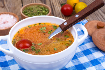 White bowl with hot vegetable soup on napkin