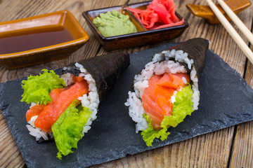 Tasty fresh sushi cone on black stone