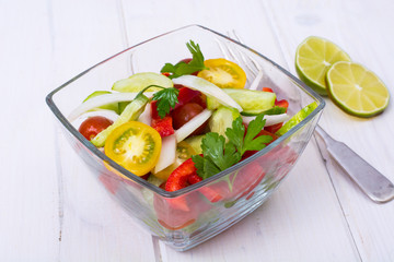 Dietary salad from tomatoes, cucumbers, white onions, lemon, oil