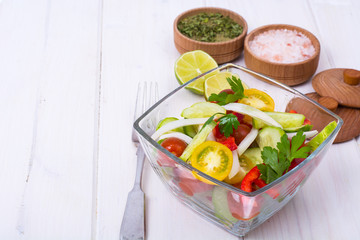 Dietary salad from tomatoes, cucumbers, white onions, lemon, oil