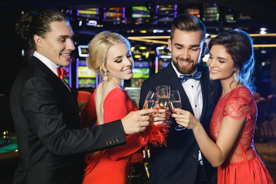 Group of happy people drinking sparkling wine in the casino