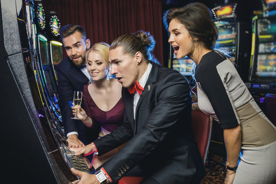 Group of friends playing slot machines