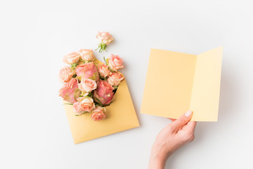 hand beside flowers in envelope