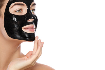 Beautiful woman with a purifying black mask on her face