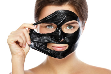 Beautiful woman is removing purifying mask from her face