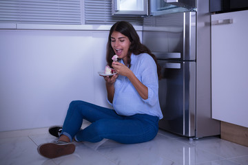 Young Woman Eating Slice Of Cake