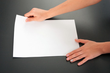 Female hands with paper on a black background. studio isolate.