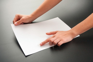 Female hands with paper on a black background. studio isolate.